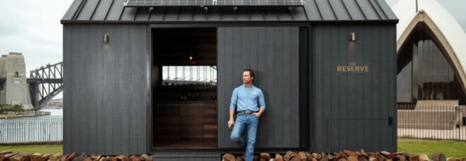 Matthew McConaughey standing in front of a dark tiny cabin