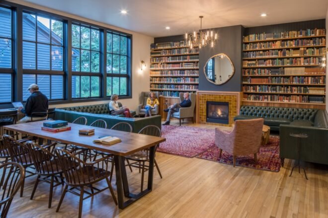 living area with sofa, long dining table, fire place and built-in bookshelves