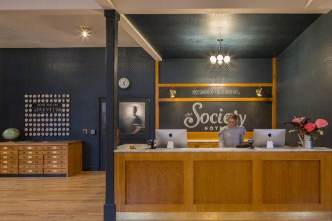 hotel reception area with dark walls and a wood desk