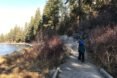 person walking on a trail near a river