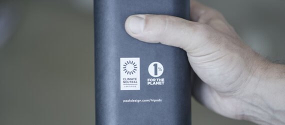 person holding container with logos for Climate Neutral Certification and 1% for the Planet