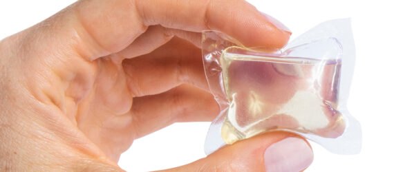 person holding clear laundry pod