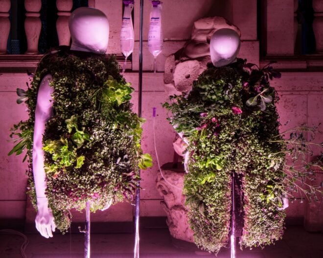 two mannequins wearing vests covered in plants