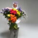 person in puffer jacket holding massive, multicolored bouquet of flowers