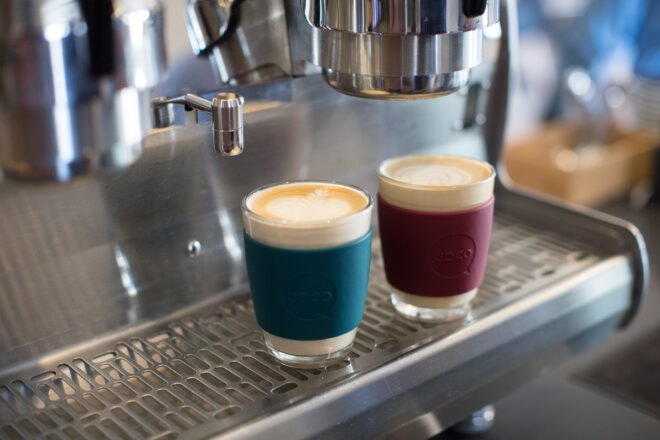 JOCO-branded glass coffee cups under an espresso machine