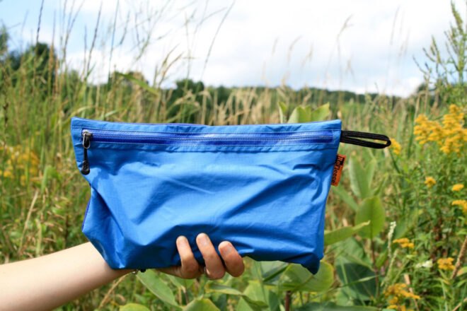 hand holding blue zipper bag