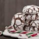 pile of chocolate crinkle cookies next to broken up candy canes