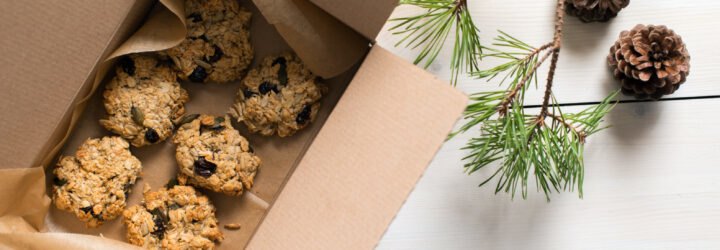 Aerial view of oatmeal raisin cookies in a box near evergreen tree branches