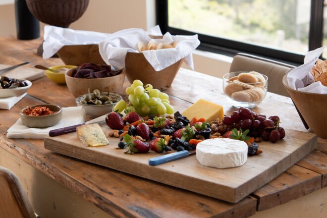 wood board with cheese, dried fruits and grapes