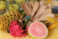wood spoons in a container surrounded by flowers and fruit