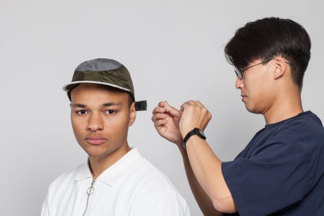 designer tightening a hat on a model