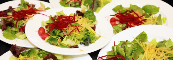 several salads on white plates