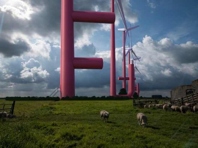 red wind turbines with extra parts on the side of the main pole