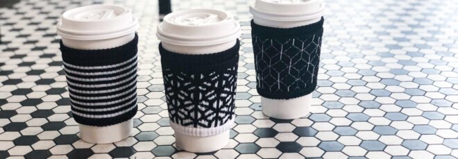 three coffee cups wrapped in black and white cloth cup sleeves
