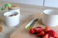 cut up strawberries near small white food storage container