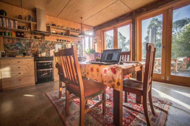 small wood dining table and chairs in light-filled kitchen