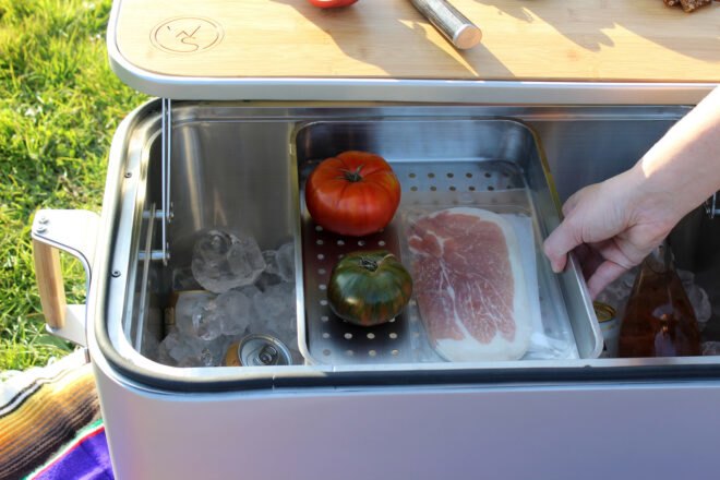 steel container holding meat and tomatoes inside a cooler