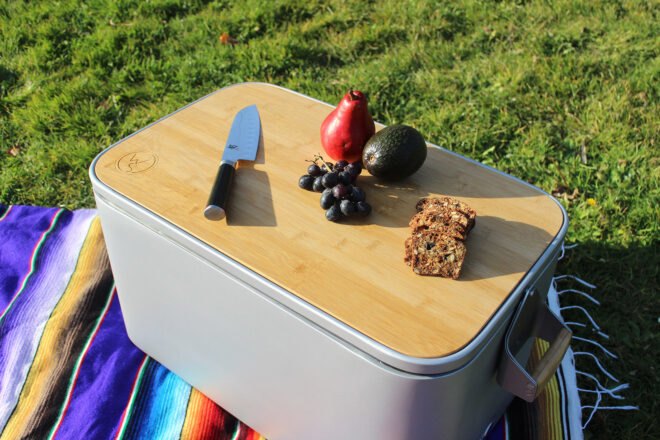 fruit, bread and knife on bamboo lid of a cooler