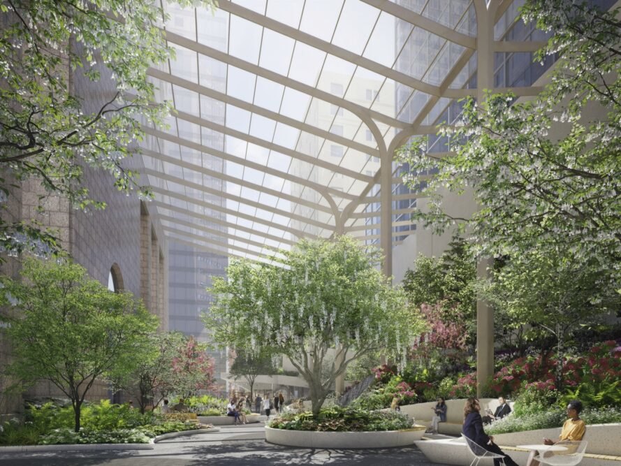 a room full of trees, with daylight coming in front the glass ceiling above. people sit in various spots throughout the room