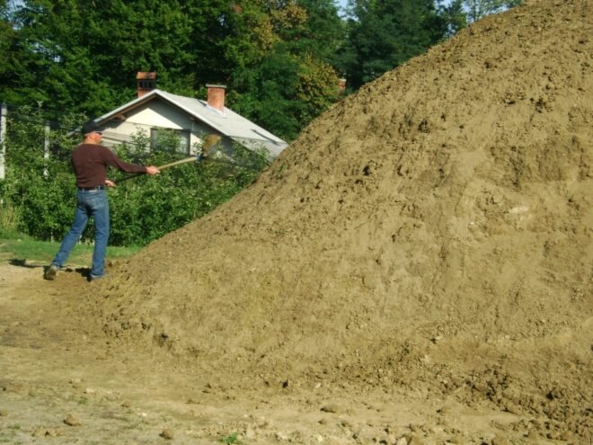 person walking by mound of dirt