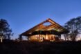 low-lying home with extended roof lit up at night