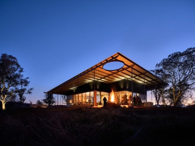 low-lying home with extended roof lit up at night