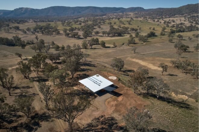 aerial shot of square home surrounded by dry fields