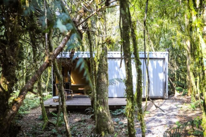 forest with white cabin with large deck