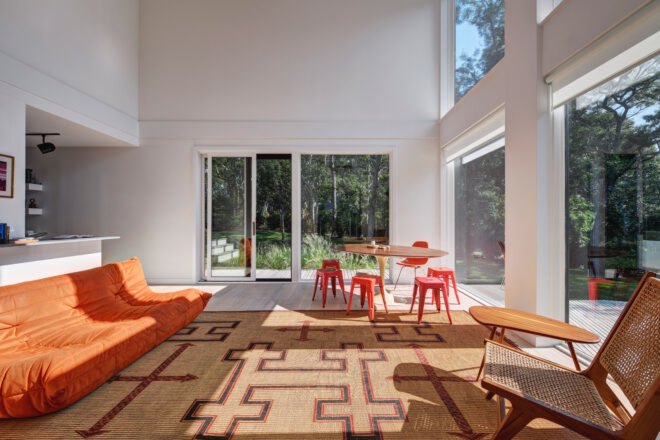 living room with double-height ceilings and orange furniture