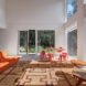 living room with double-height ceilings and orange furniture