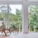 small wood chair beside glass wall