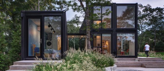 black shipping container home with glass walls