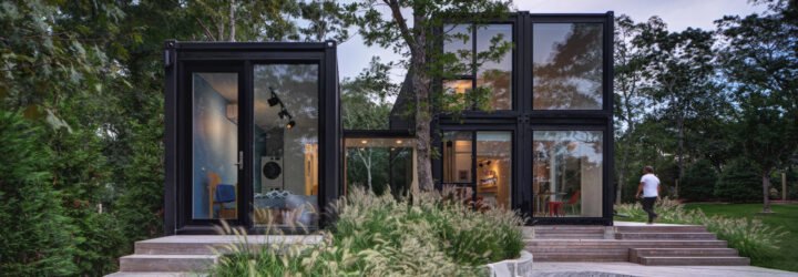 black shipping container home with glass walls