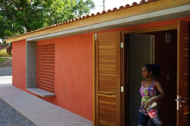 a red building with open doors that a woman is walking out of