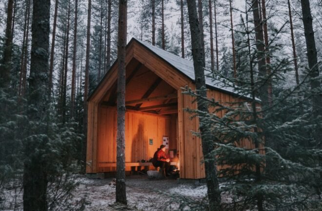 warm glow from a firepit inside a gabled wood structure in the woods