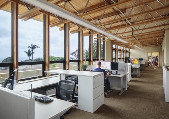 white desks near wall of glass with views of Pacific Ocean