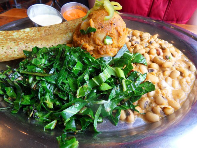 a plate of food featuring greens, beans and sweet potatoes