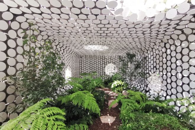 inside the building, the interior is a lush, green plant-filled area. circular cut-outs make up the interior walls