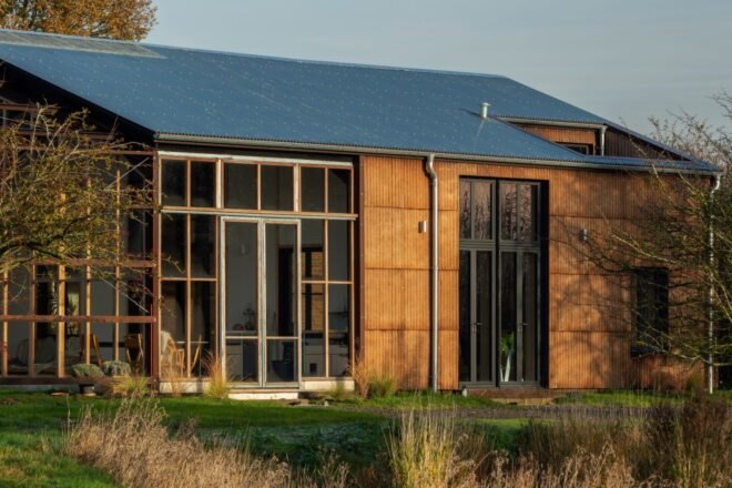 pitched-roof home with large wall made out of glass panels