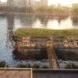 Rendering of floating office building with half a green roof and the other half of the roof covered in solar panels