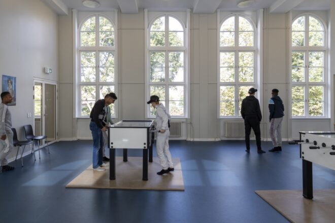 kids standing in large white room with blue floors