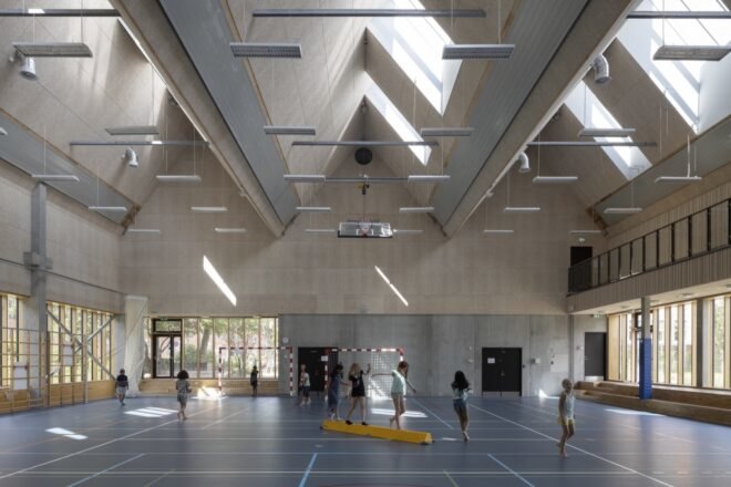 kids in gymnasium with pitched ceilings and skylights