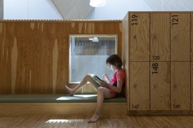 kid reading a book in a wood reading nook