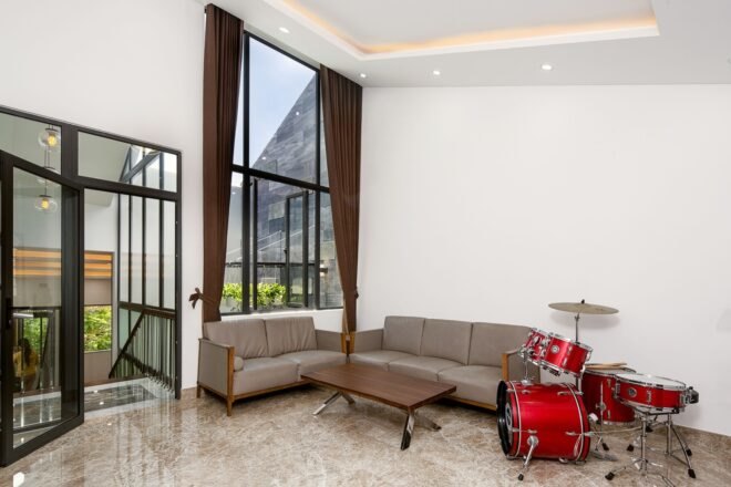 two tan sofas beside a red drum set