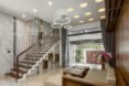 tan and wood sofa in white room with circular chandeliers
