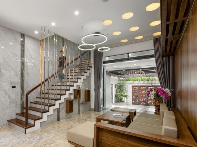 tan and wood sofa in white room with circular chandeliers