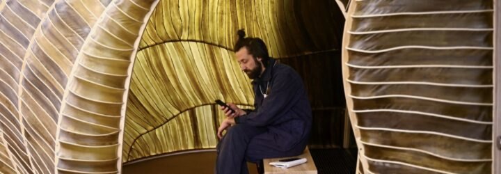 person sitting on a bench inside a seaweed pavilion
