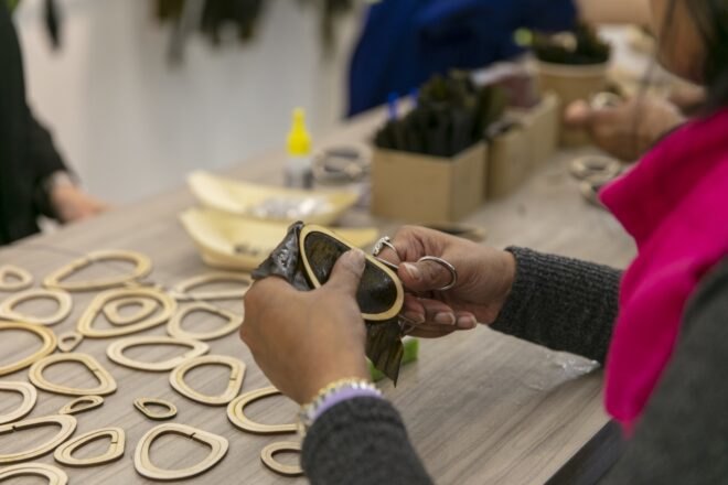 person attaching seaweed to wooden circle