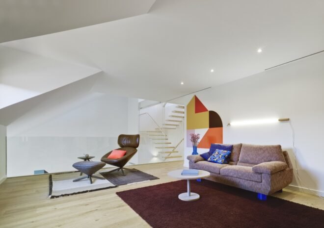 living area with tan sofa, blue pillows and brown rug