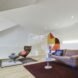 living area with tan sofa, blue pillows and brown rug